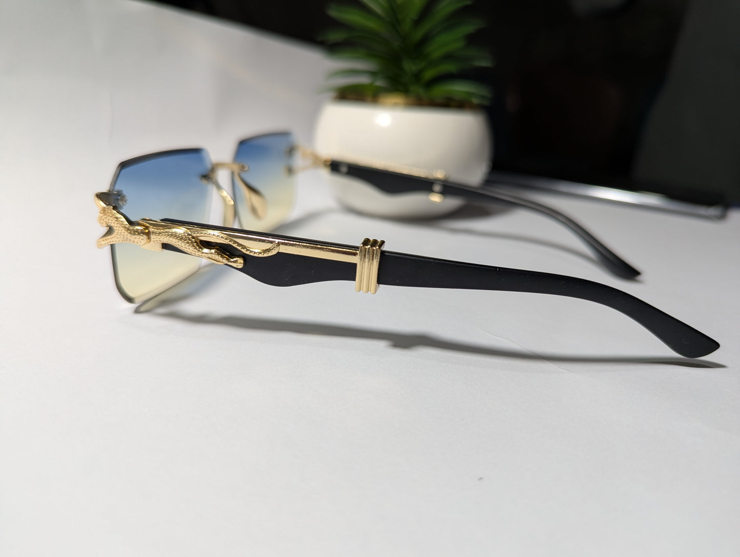 The Apex Predator: Gold & Black Rimless Sunglasses with Stylized Jaguar/Serpent Temples